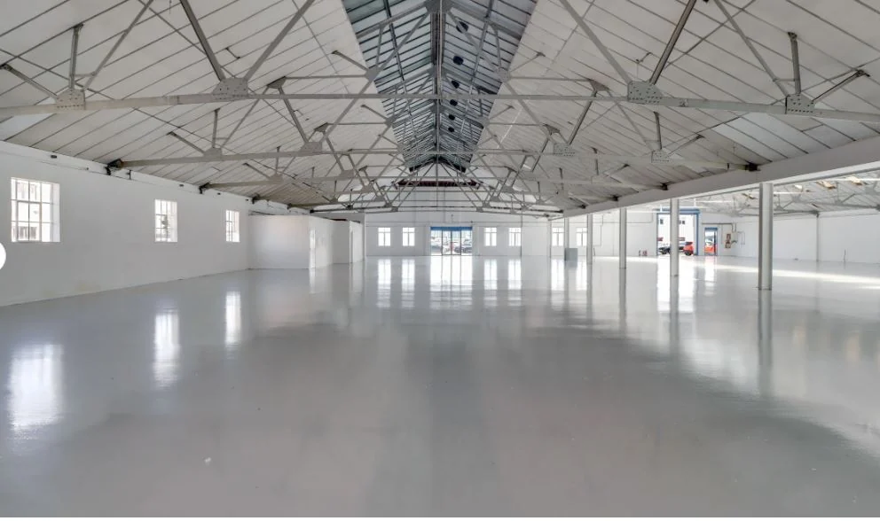 Central Avenue West Molesey warehouse with a finished grey floor, white steel roof trusses and rooflights